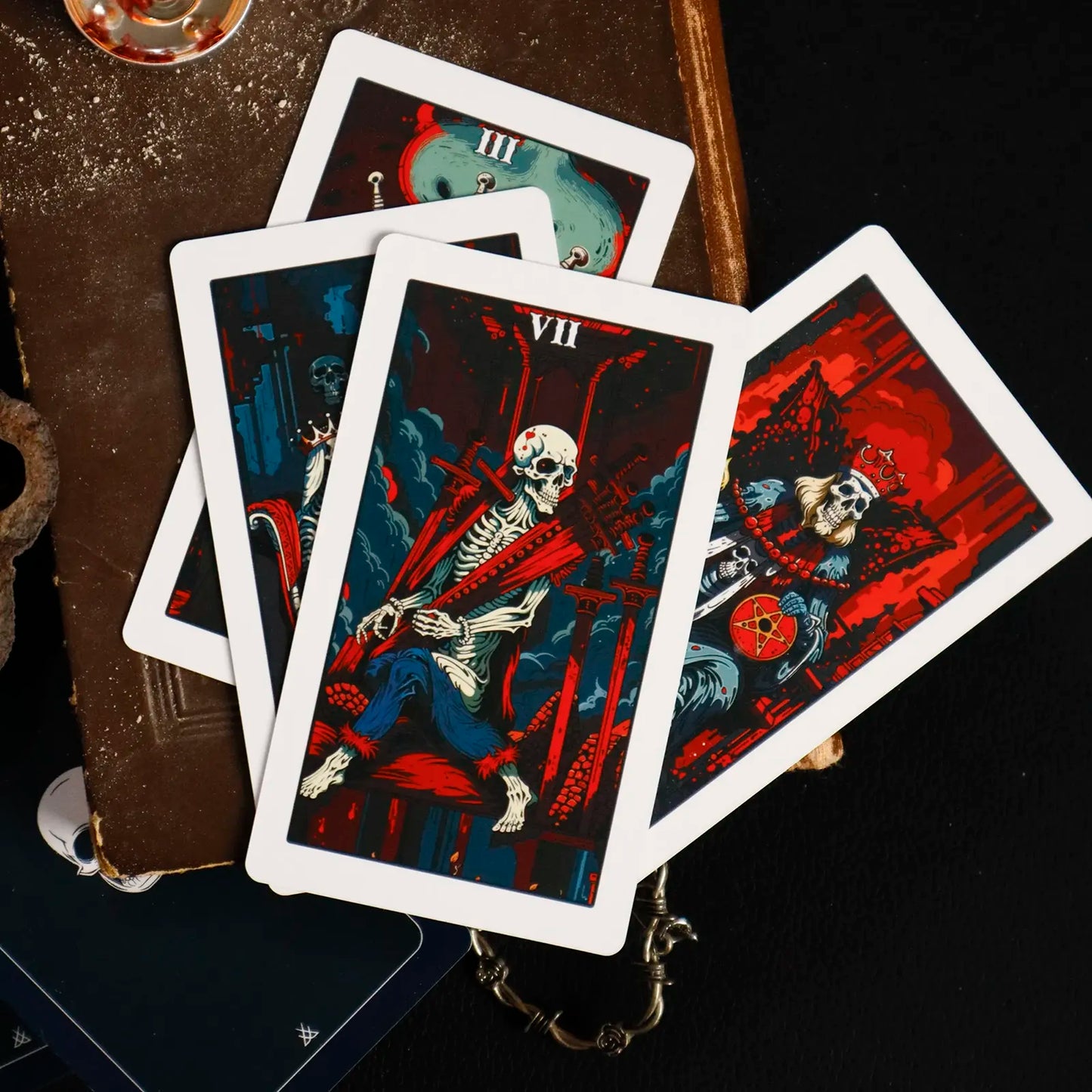 Set of tarot cards with dark, artistic designs on a wooden surface.