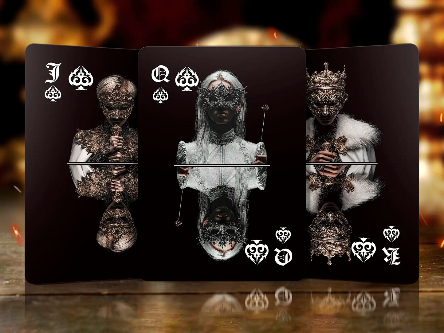 Set of playing cards with black backgrounds and white card suits on a reflective surface.