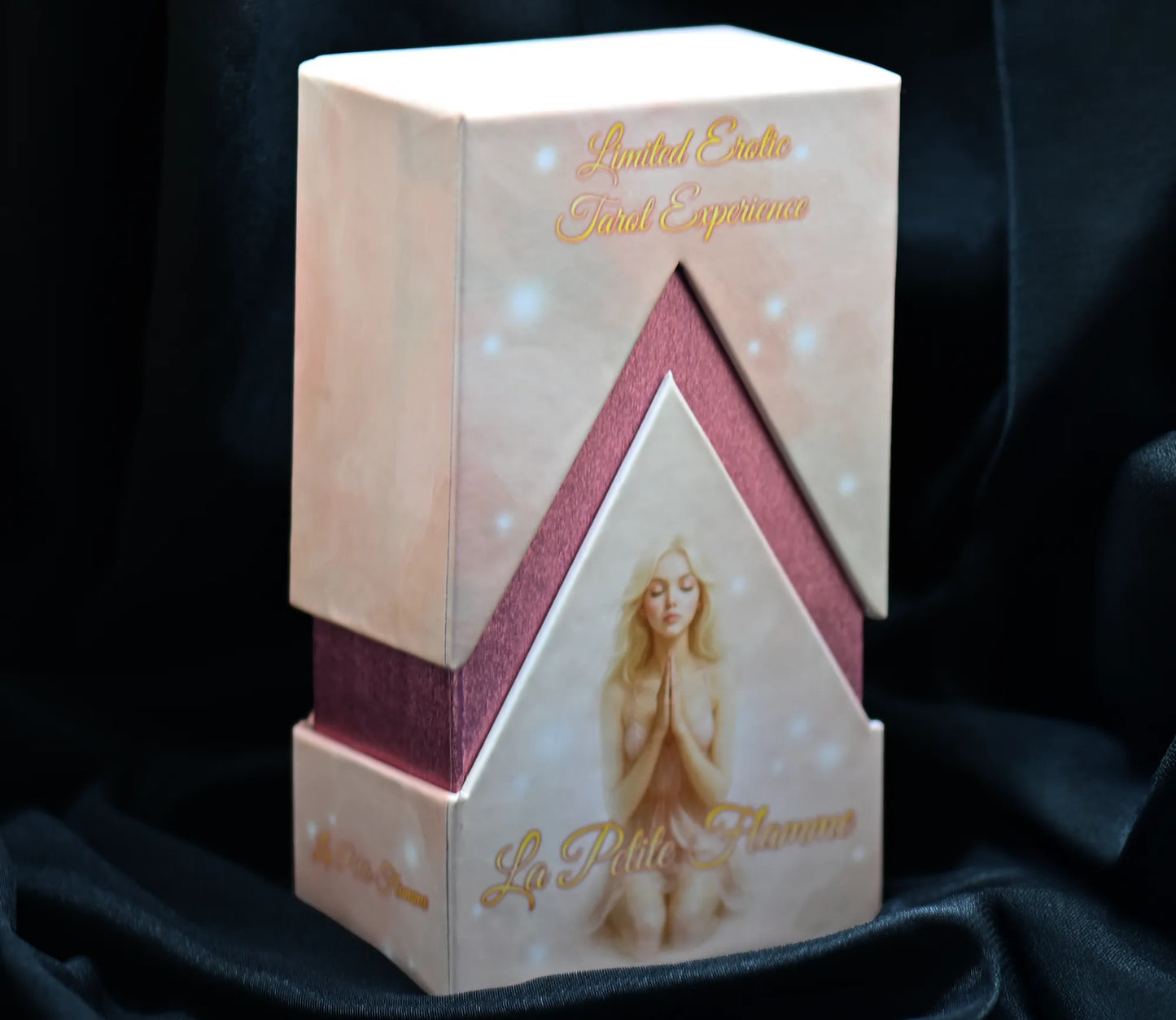 Decorative box with a woman's face and 'La Petite Flamme' branding on a dark fabric background