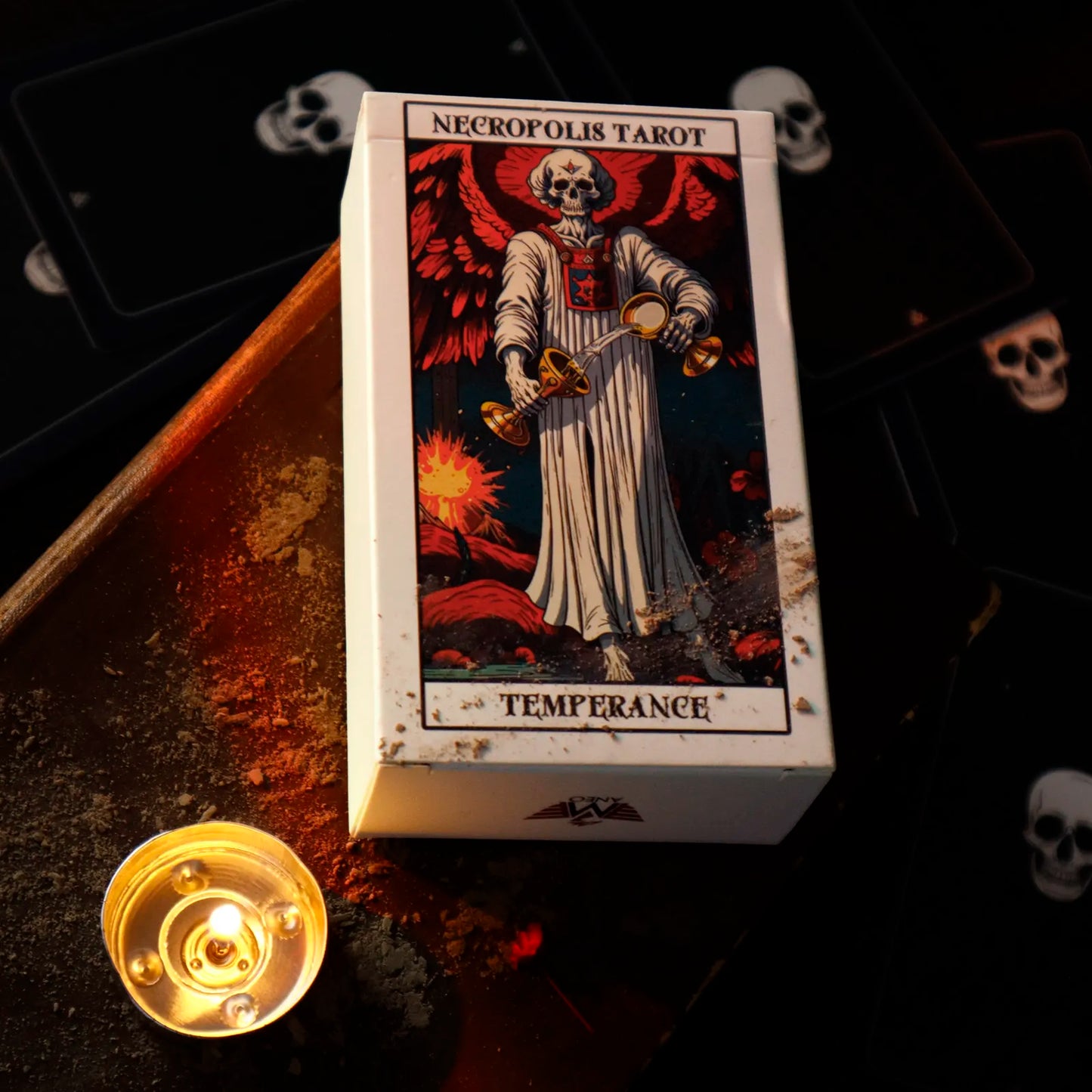 Necropolis Tarot Temperance card box with a candle and tarot cards in the background