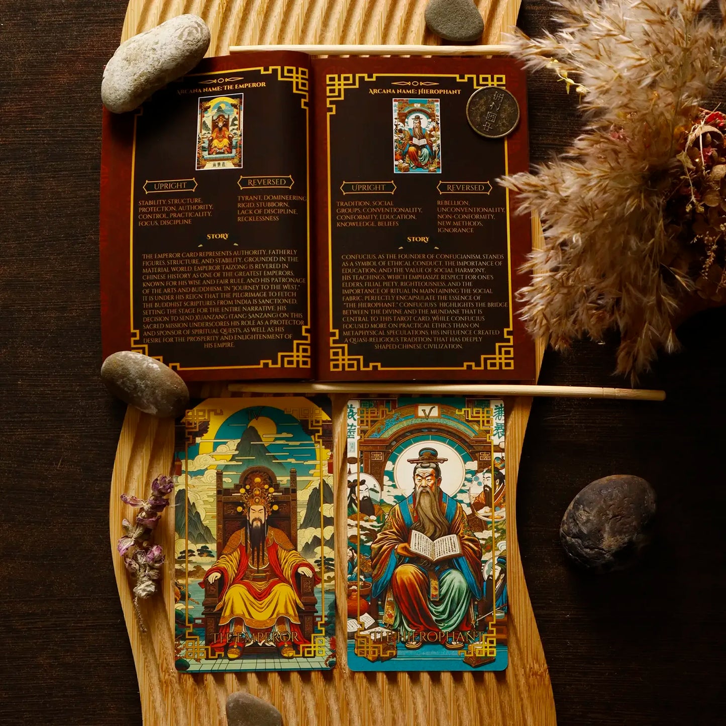 Open tarot card deck with cards displayed on a wooden board, surrounded by stones and feathers.