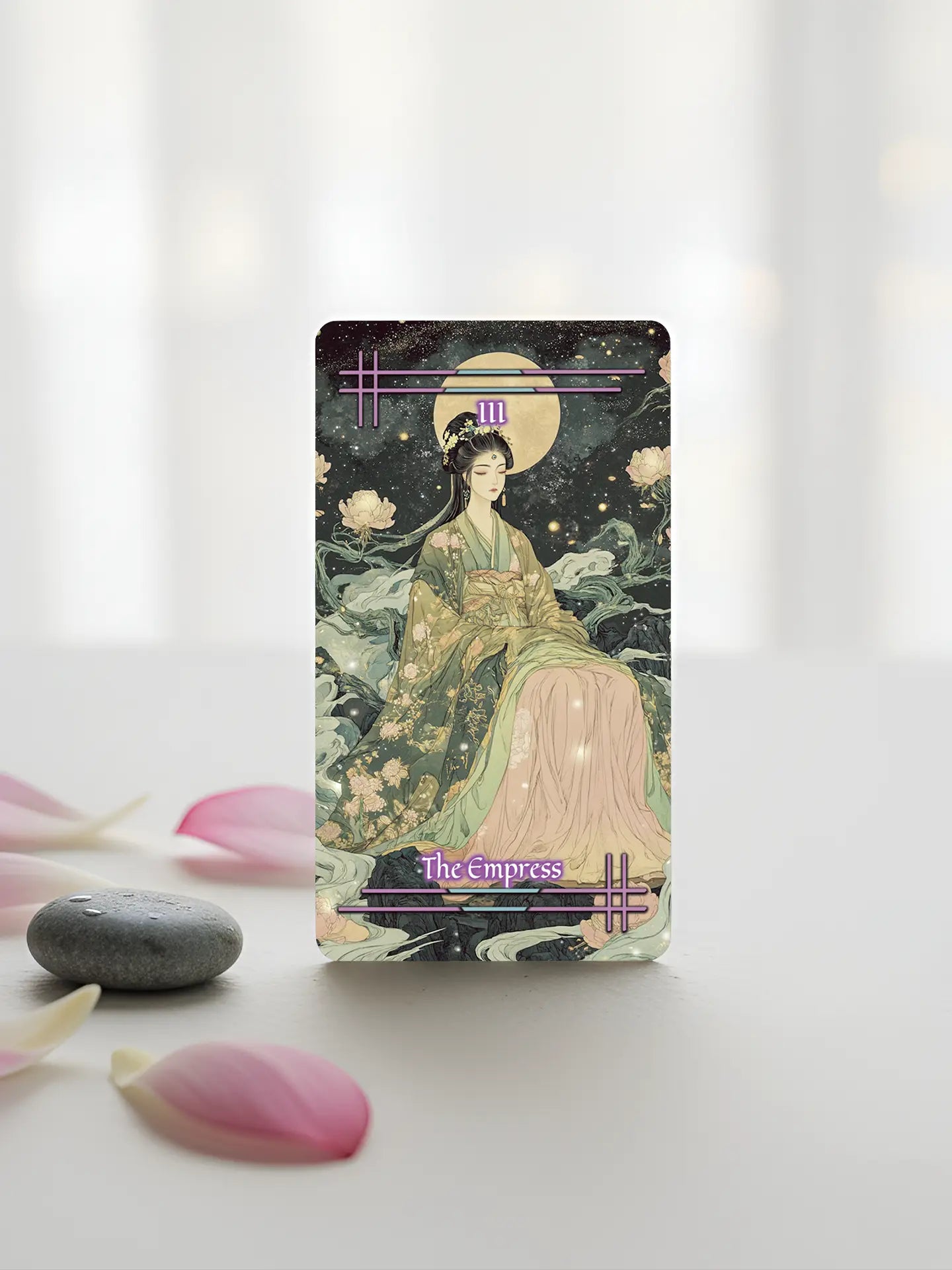 Card featuring an illustration of a woman in traditional attire with 'The Empress' text, surrounded by flowers and stones on a light background.
