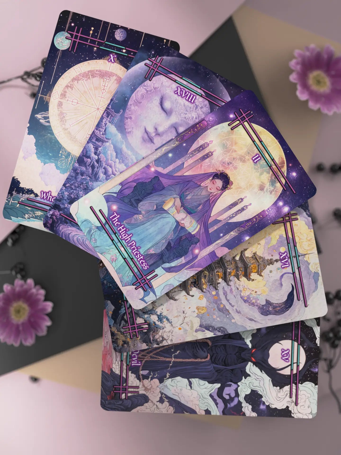 Stack of tarot cards with artistic designs on a surface with flowers.