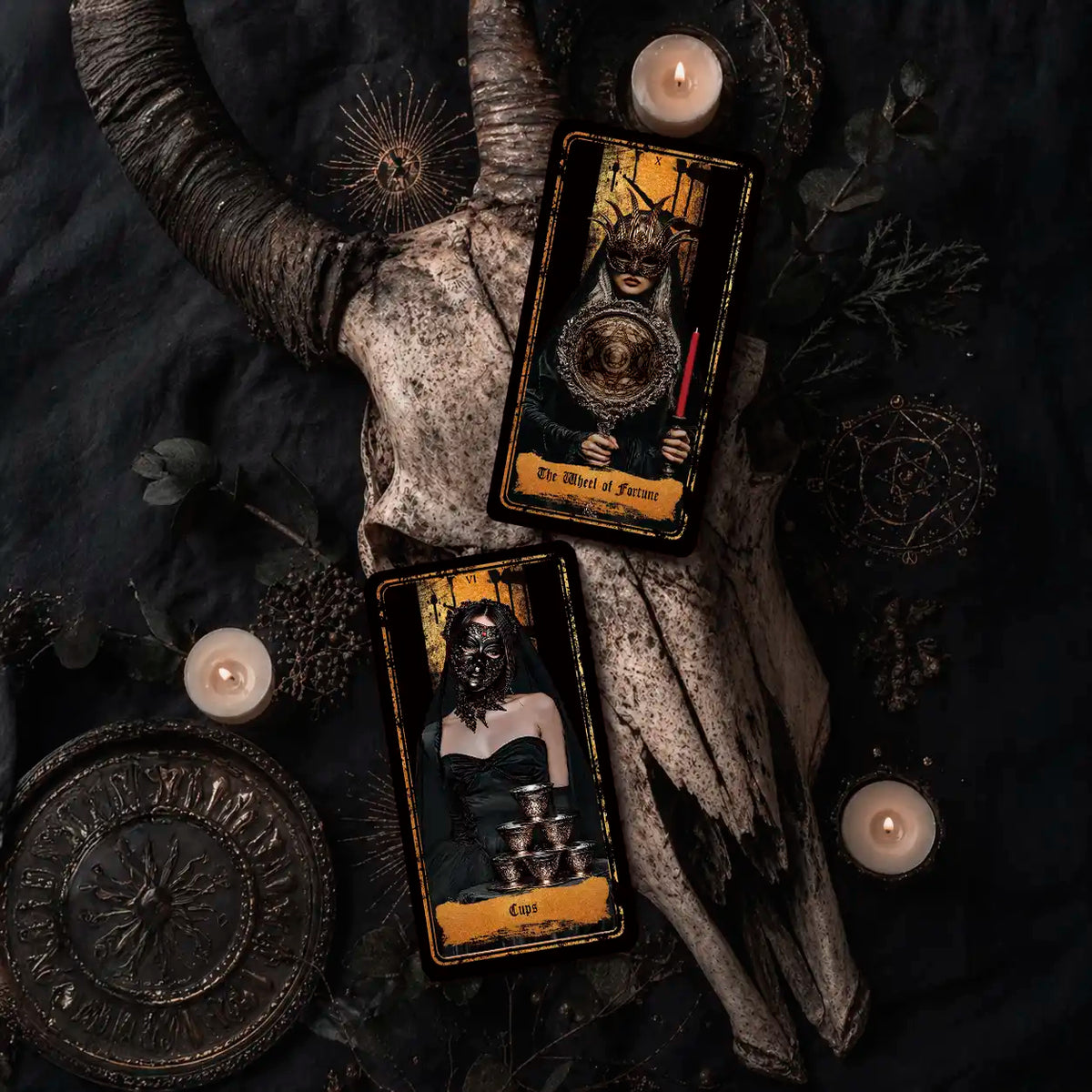 Persona Obscura Tarot The Wheel of Fortune and Cups cards on ram skull with candles, gothic flat lay