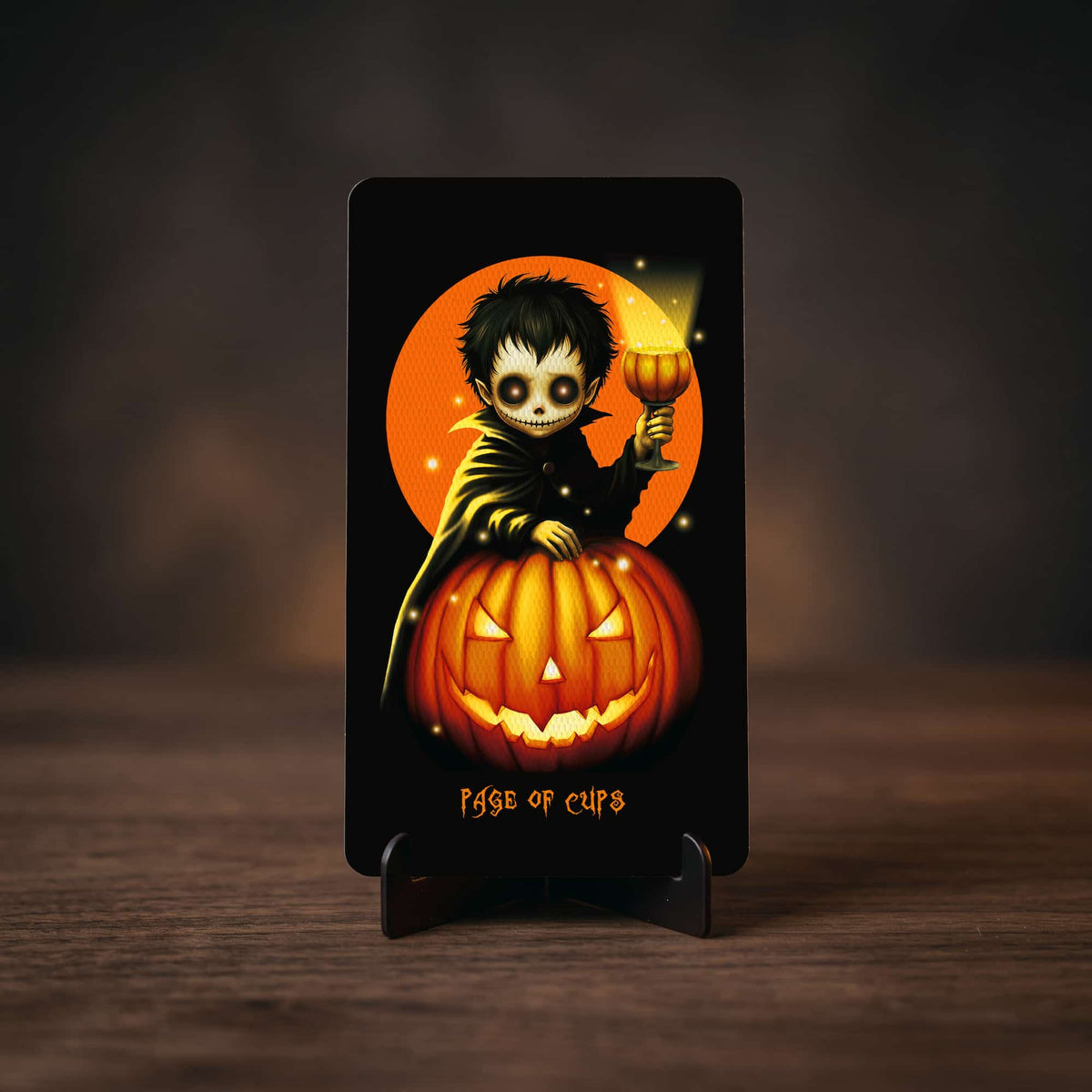 Halloween Tarot Page of Cups card, vampire child with glowing goblet on jack-o'-lantern