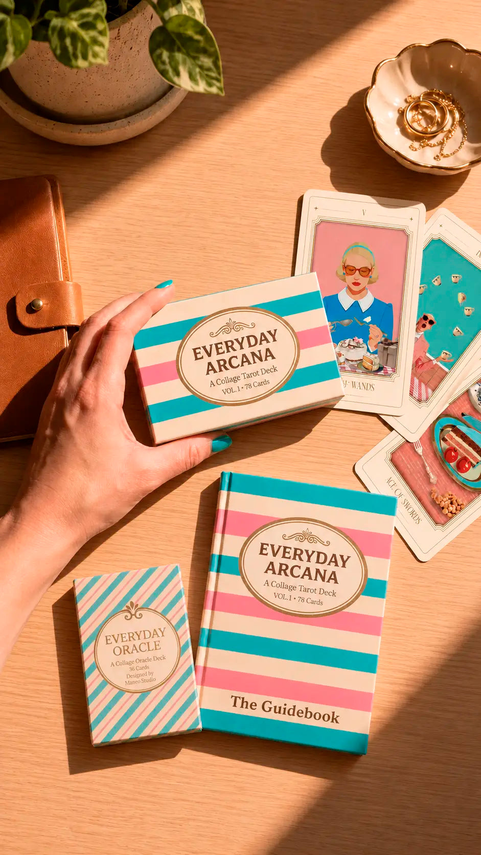 Everyday Arcana oracle cards and guidebook on a wooden surface with a hand holding the cards.