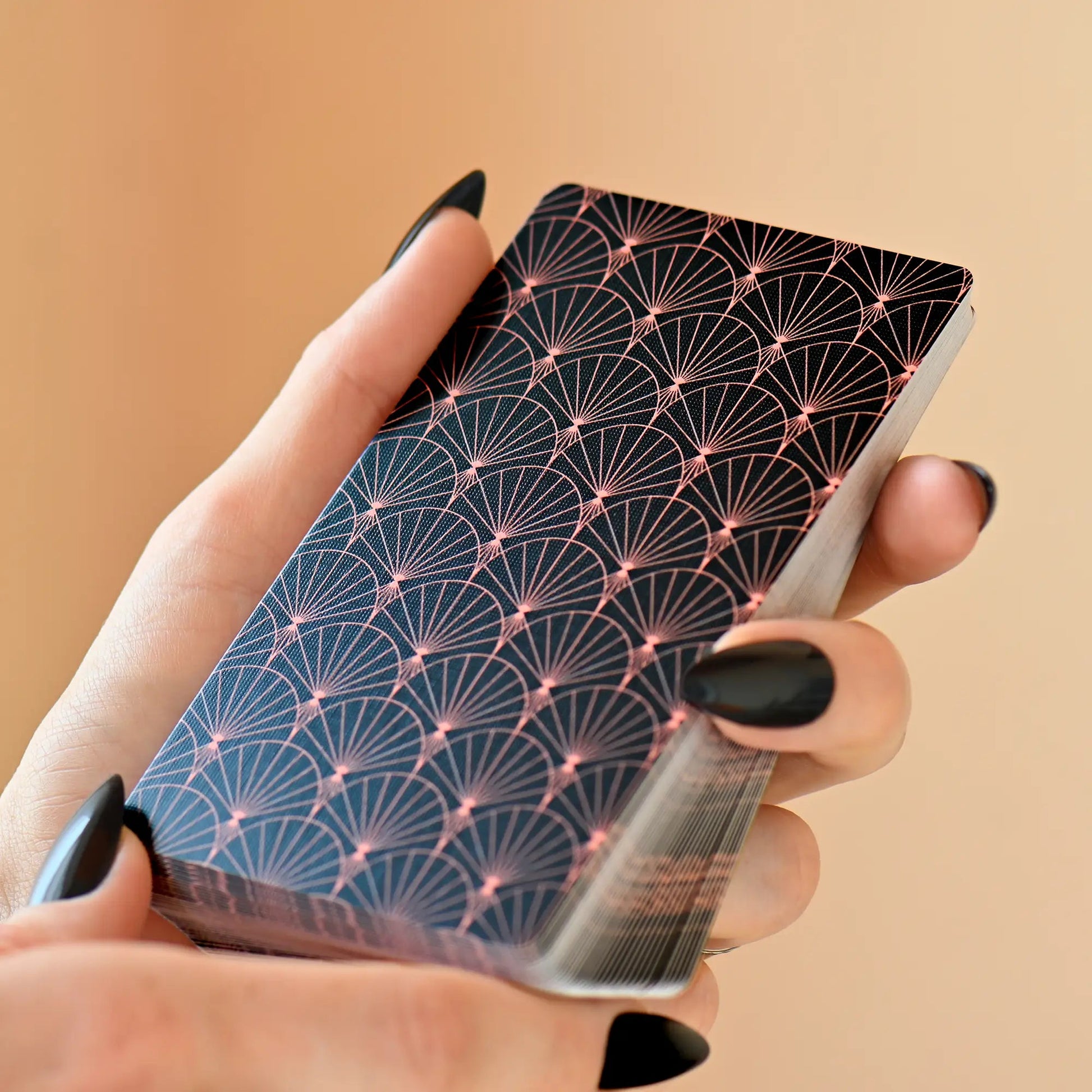 Geisha no Tamashii Tabi Lenormand deck held in hand showing black and gold Japanese pattern card backs 
