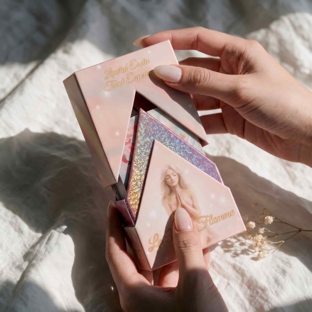 Hands opening La Petite Flamme Tarot pink box with holographic inner lining, limited edition romantic deck