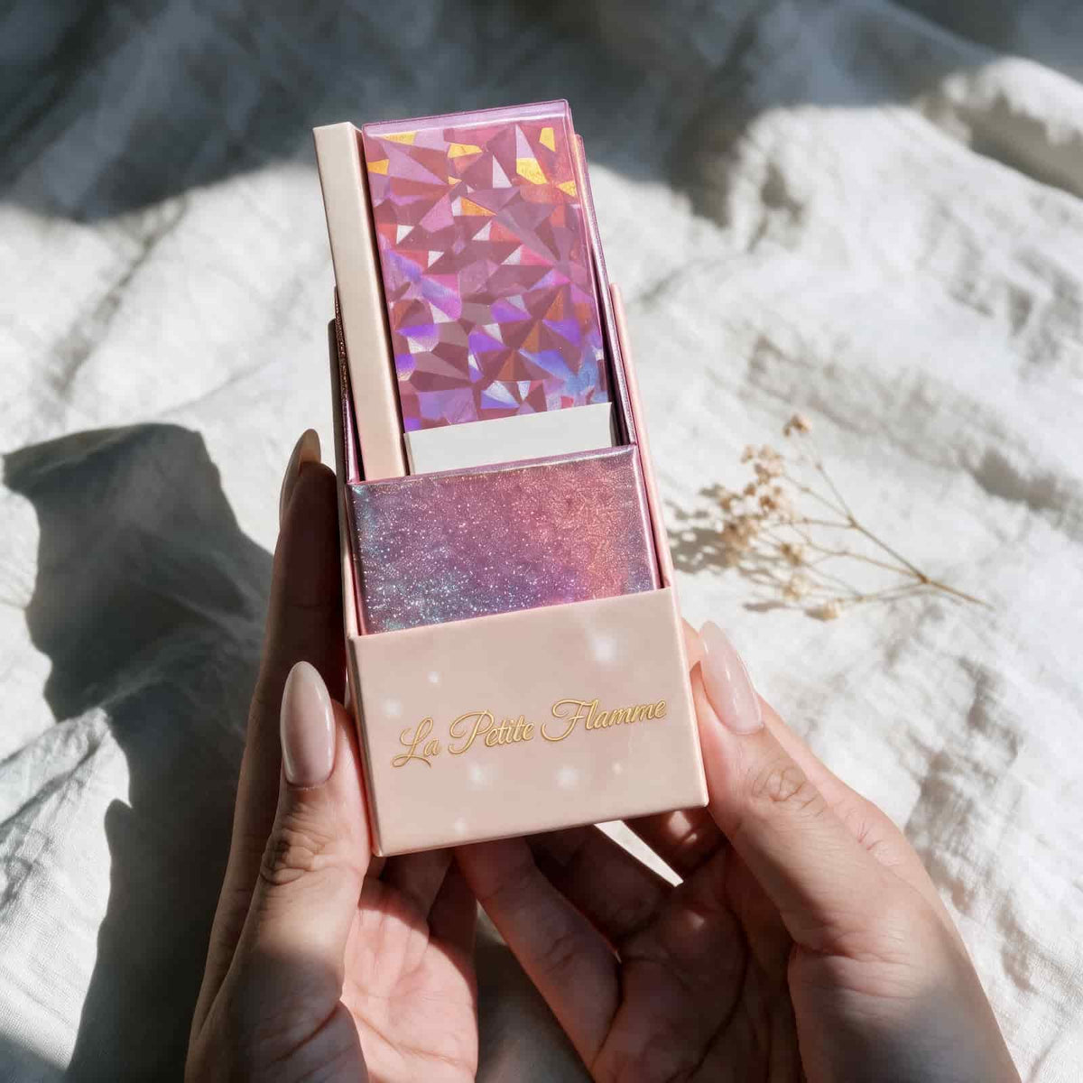 La Petite Flamme Tarot open box with holographic card deck inside, blush pink packaging with gold foil title