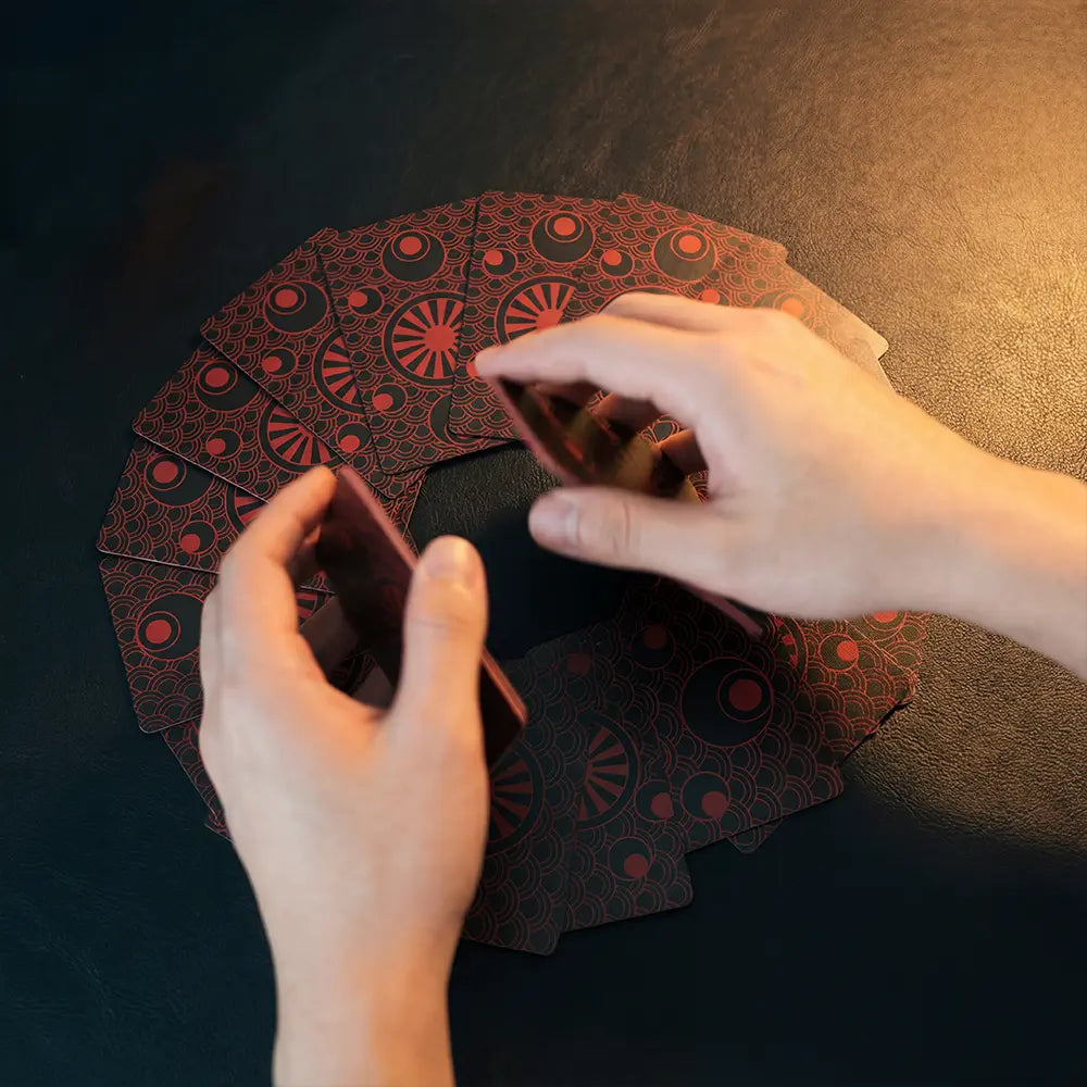 A lifestyle photo of hands shuffling the Yakuza Tarot Deck, emphasizing the smooth handling of 350gsm anti-scratch matte linen cardstock and the bold crimson-on-black back design. Targets searches like tarot deck shuffle test, professional tarot tools, durable tarot cards, and beginner-friendly tarot with guidebook.