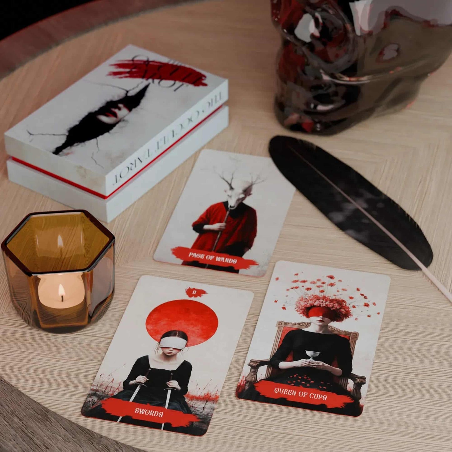Set of  Occult tarot cards with decorative box, candle, and feather on a wooden surface. Red and white color 