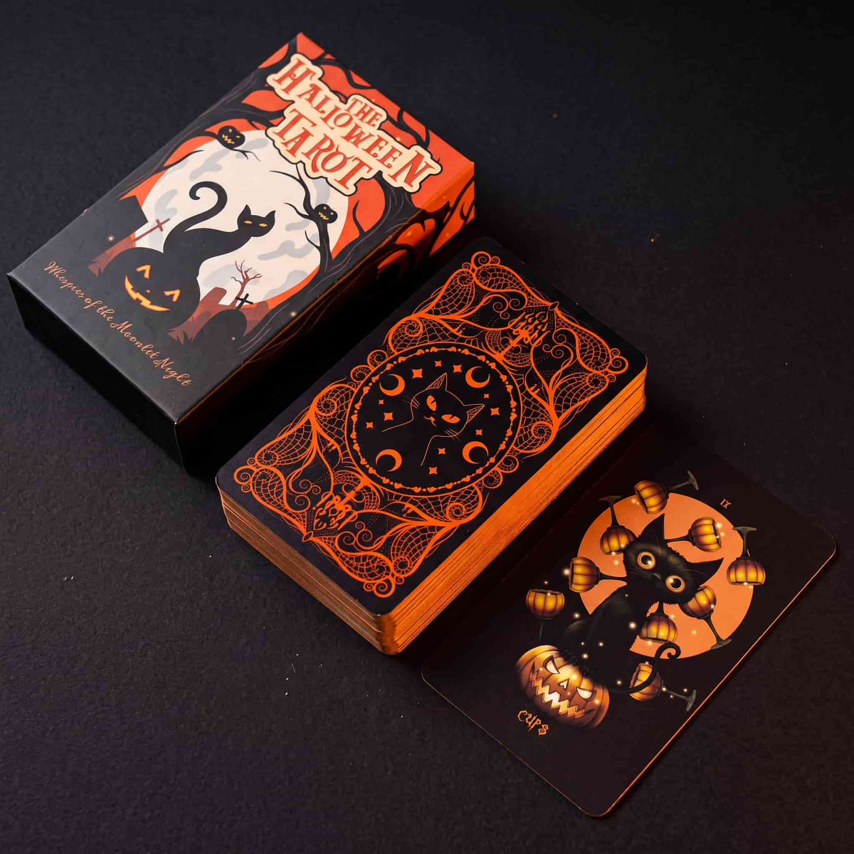 Halloween Tarot collector box, orange card back and Nine of Cups card displayed on dark background with pumpkin orange gilded edges
