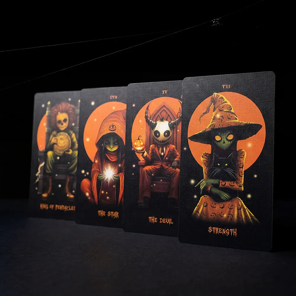 Row of Halloween Tarot cards including Strength, Devil, Star, and King of Pentacles on dark background