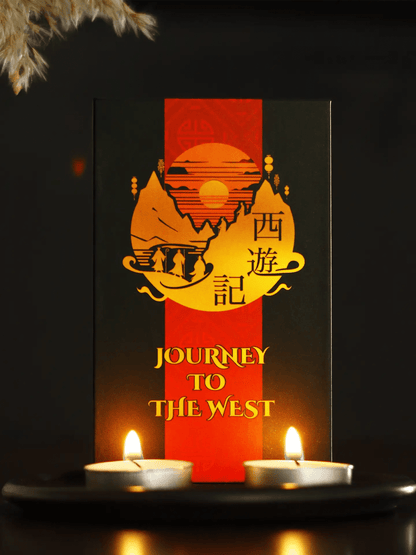 Journey to the West Tarot box, black and red with golden sun and Chinese characters, between two candles