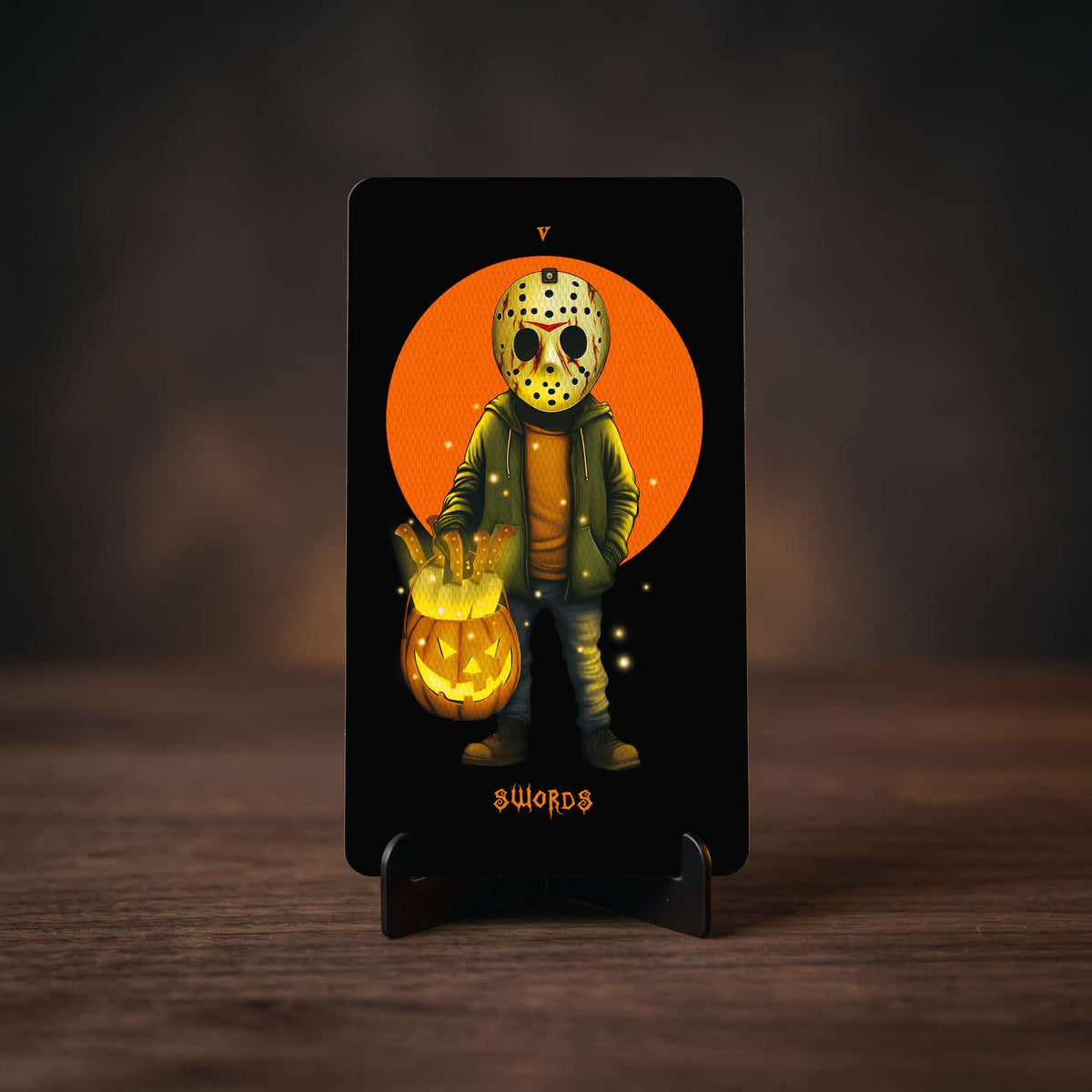 Halloween Tarot Five of Swords card, hockey-masked slasher holding a jack-o'-lantern bucket