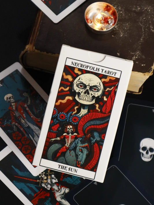 Necropolis Tarot card featuring a skull design on a dark surface with candles.