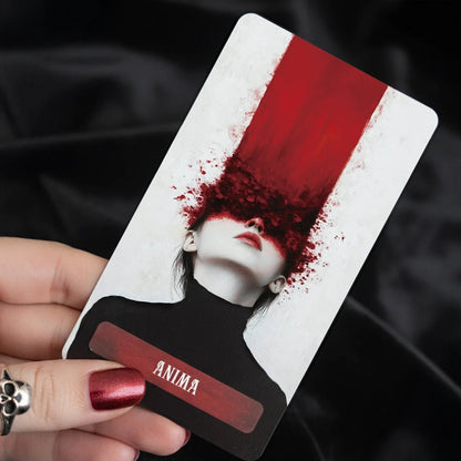 Occult Anima card with red abstract face design held in hand against dark background