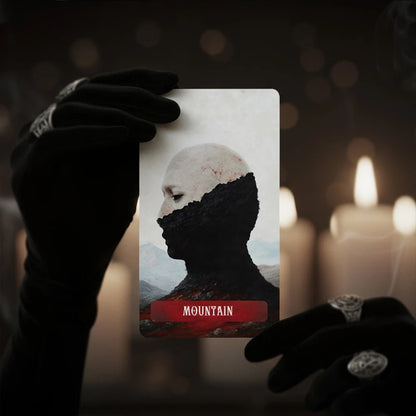 Occult Lenormand Mountain card held in black gloves with candles in dark mystical reading atmosphere