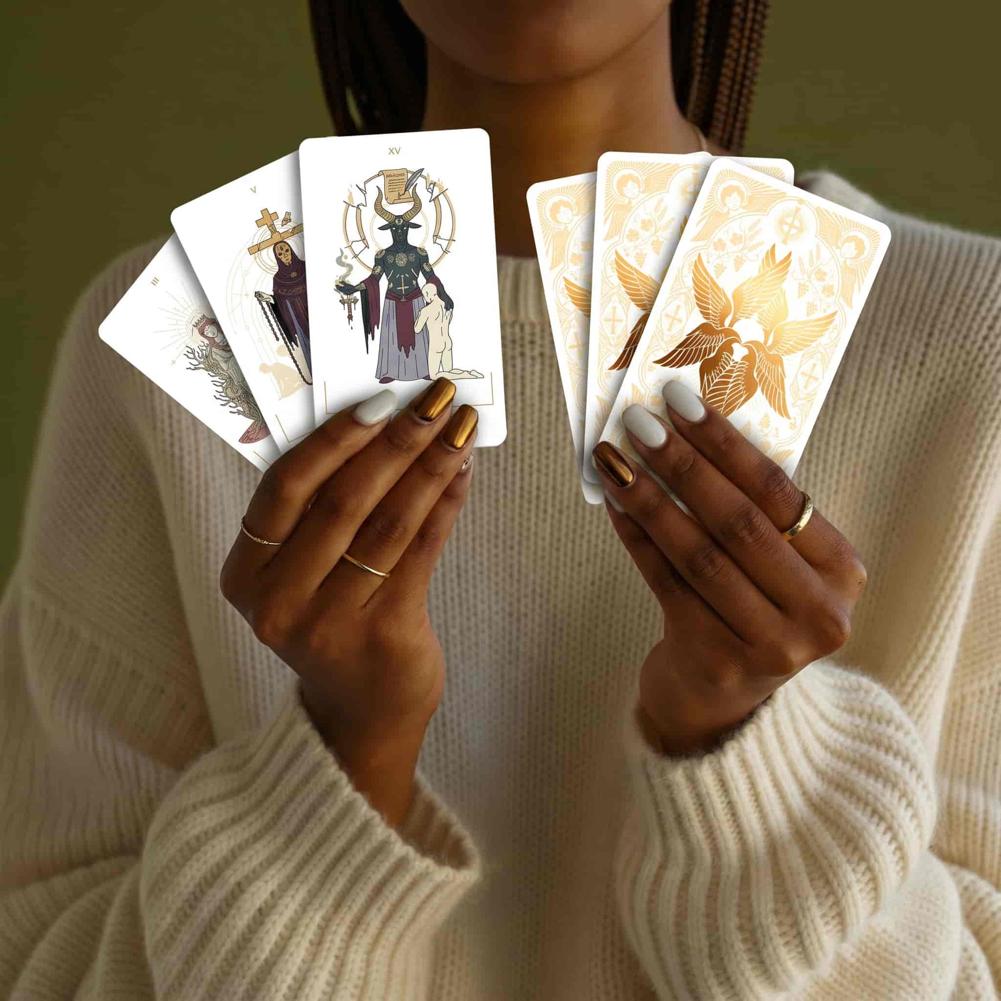 Woman holding Seraphim Tarot card fronts and card backs with a central gold foil angel emblem.