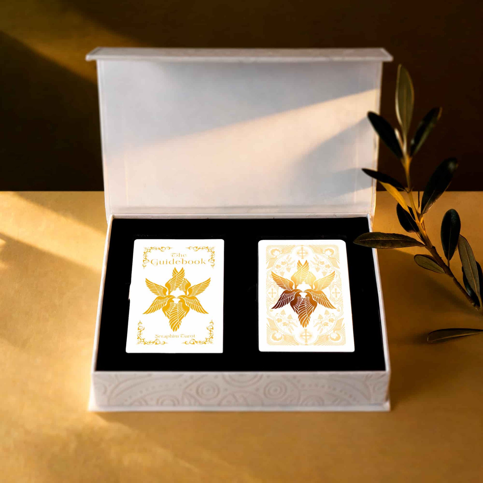 Open Seraphim Tarot collector box containing the printed guidebook and 78-card deck in a black fitted insert.