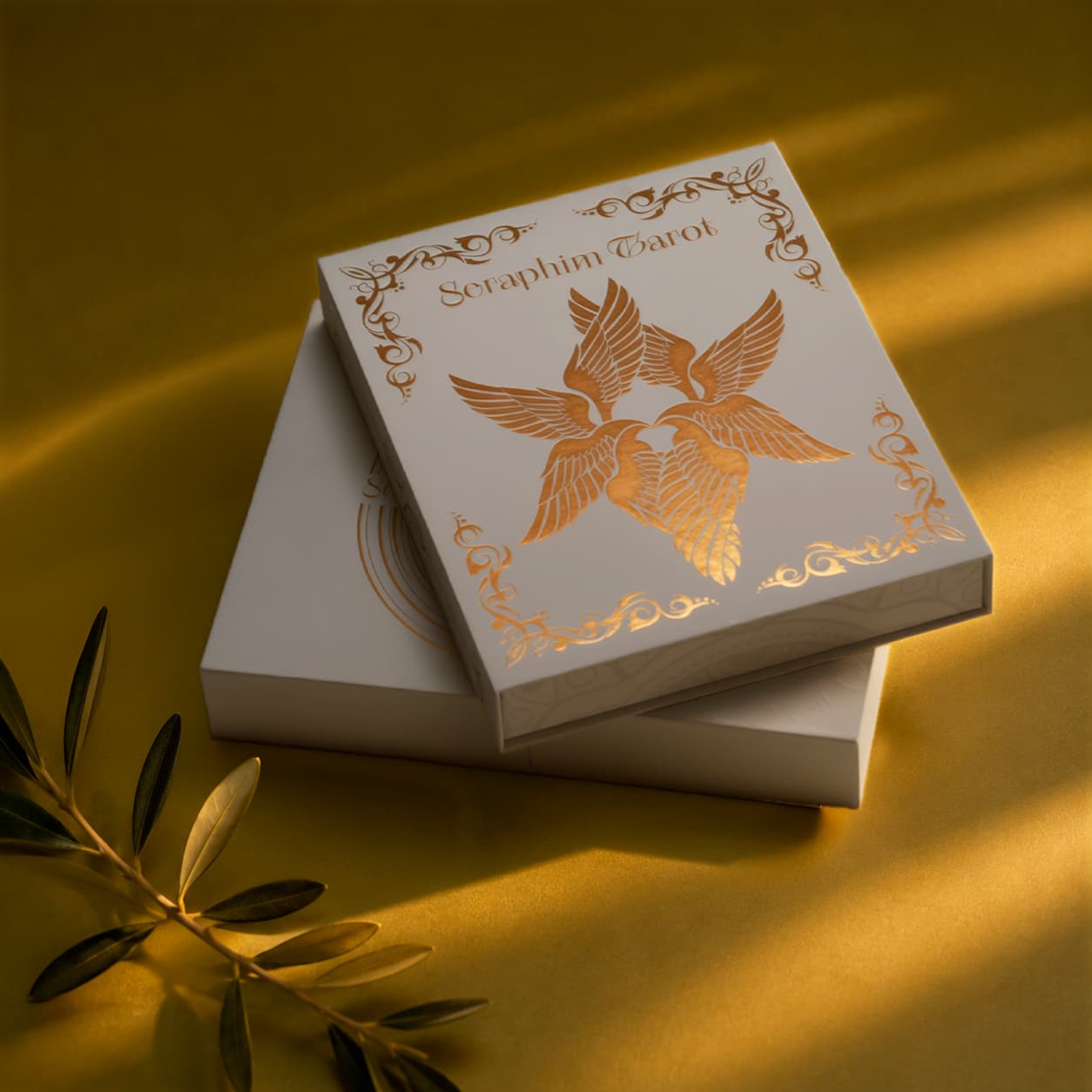 Seraphim Tarot collector boxes with embossed white packaging and gold foil angel design on an olive-gold background.