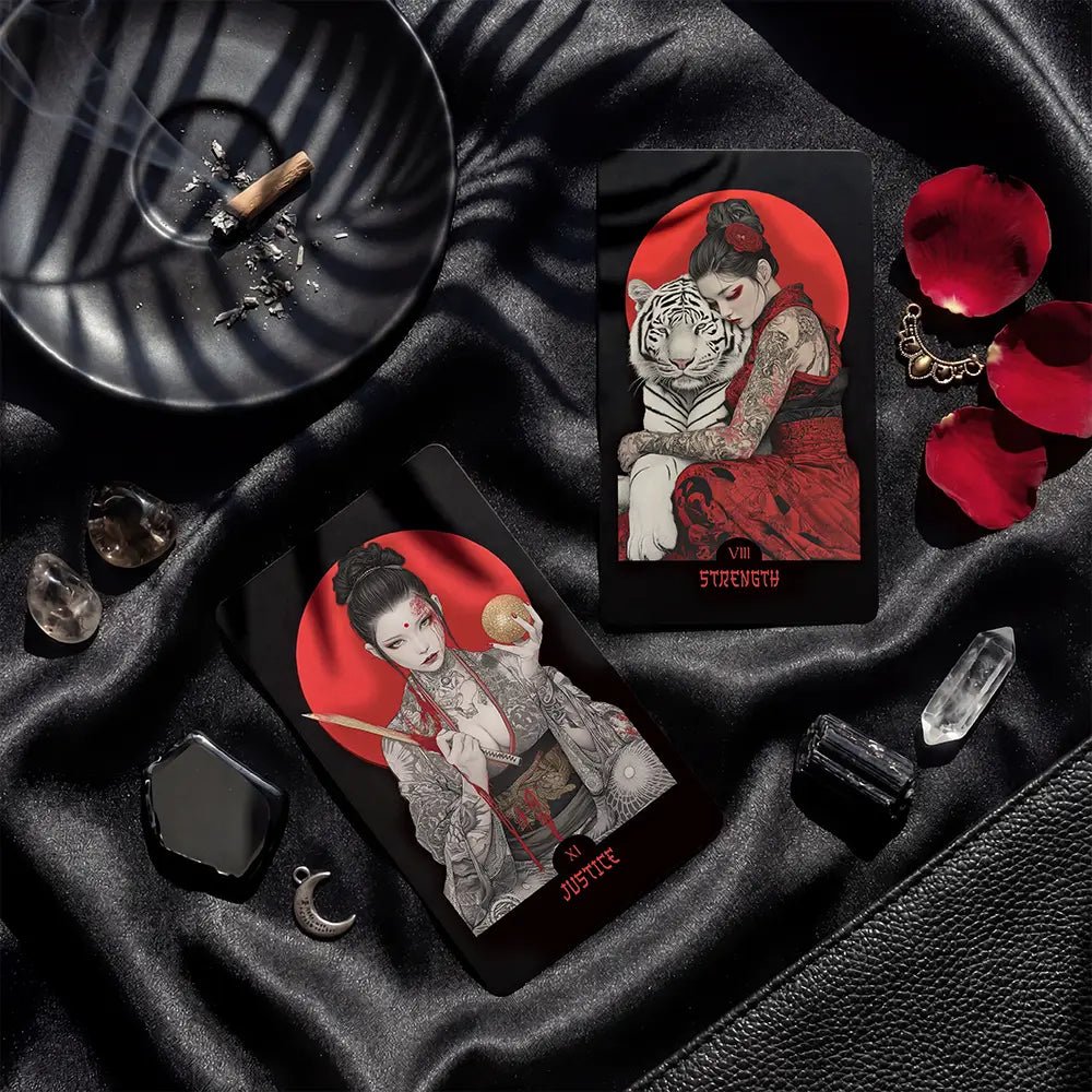 Yakuza Tarot cards Strength and Justice displayed on black silk with crystals, petals and dramatic lighting
