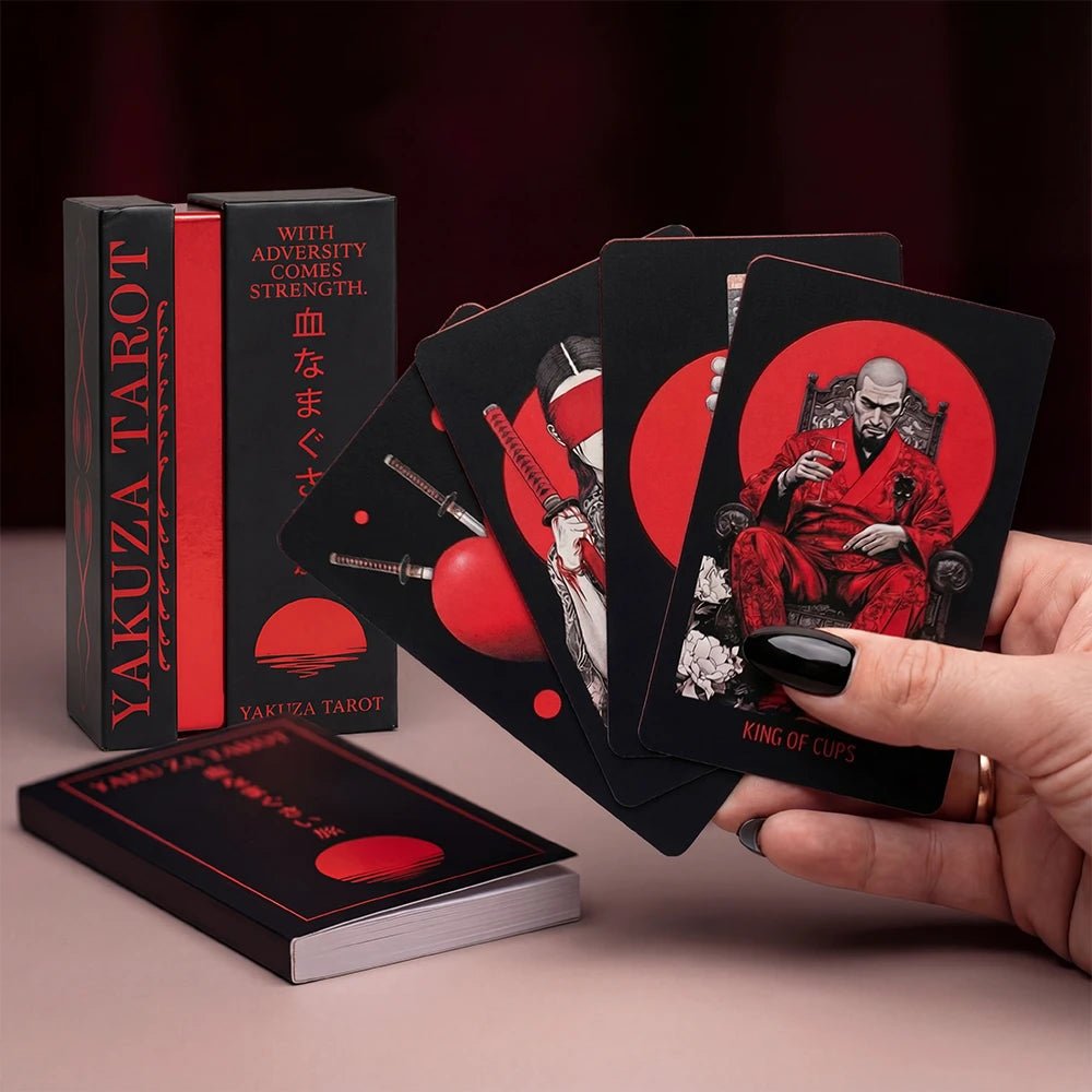 Hand fanning Yakuza Tarot cards with matching box and guidebook, red edge visible